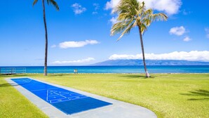 Ein Shuffleboard-Feld mit freiem Blick auf das Meer und die Berge im Hintergrund.