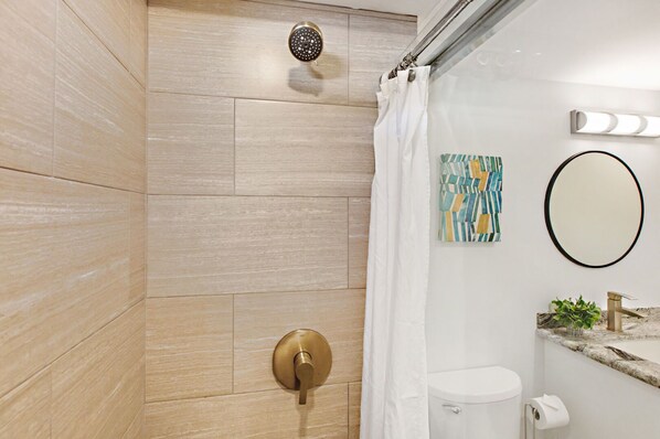Une salle de bain moderne équipée d’une douche, de toilettes et d’un lavabo.