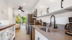 A modern kitchen with stainless steel appliances, a built-in oven, and a coffee maker.