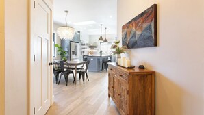 Eine moderne Küche mit Essbereich, Holzschränken und einem Kronleuchter.
