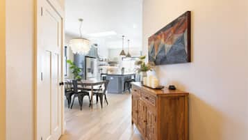 A modern kitchen with a dining area, wooden cabinetry, and a chandelier.