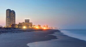 Enjoy stunning ocean views from a high-rise building overlooking a wide, popular beach.