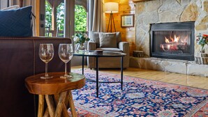 A cozy living room with a fireplace, a wooden coffee table, and a patterned rug. - HUGE AMAZING Mtn Views!  Great Location! Hot Tub! Game Room! Spacious! Privacy! (Sevierville)