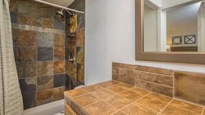 A bathroom with a shower, a bathtub, and a vanity with a mirror.