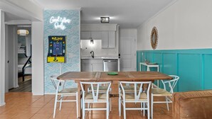 Een moderne keuken met witte kasten, een roestvrijstalen vaatwasser en een neonreclame op de muur.