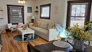 Una sala de estar acogedora con sofá, sillón, mesa de centro y elementos decorativos.