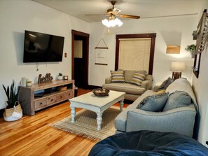 Relax in this inviting living room with a flat-screen TV, entertainment center, and comfortable sofa.