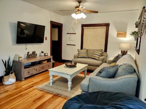 Relax in this inviting living room with a flat-screen TV, entertainment center, and comfortable sofa.