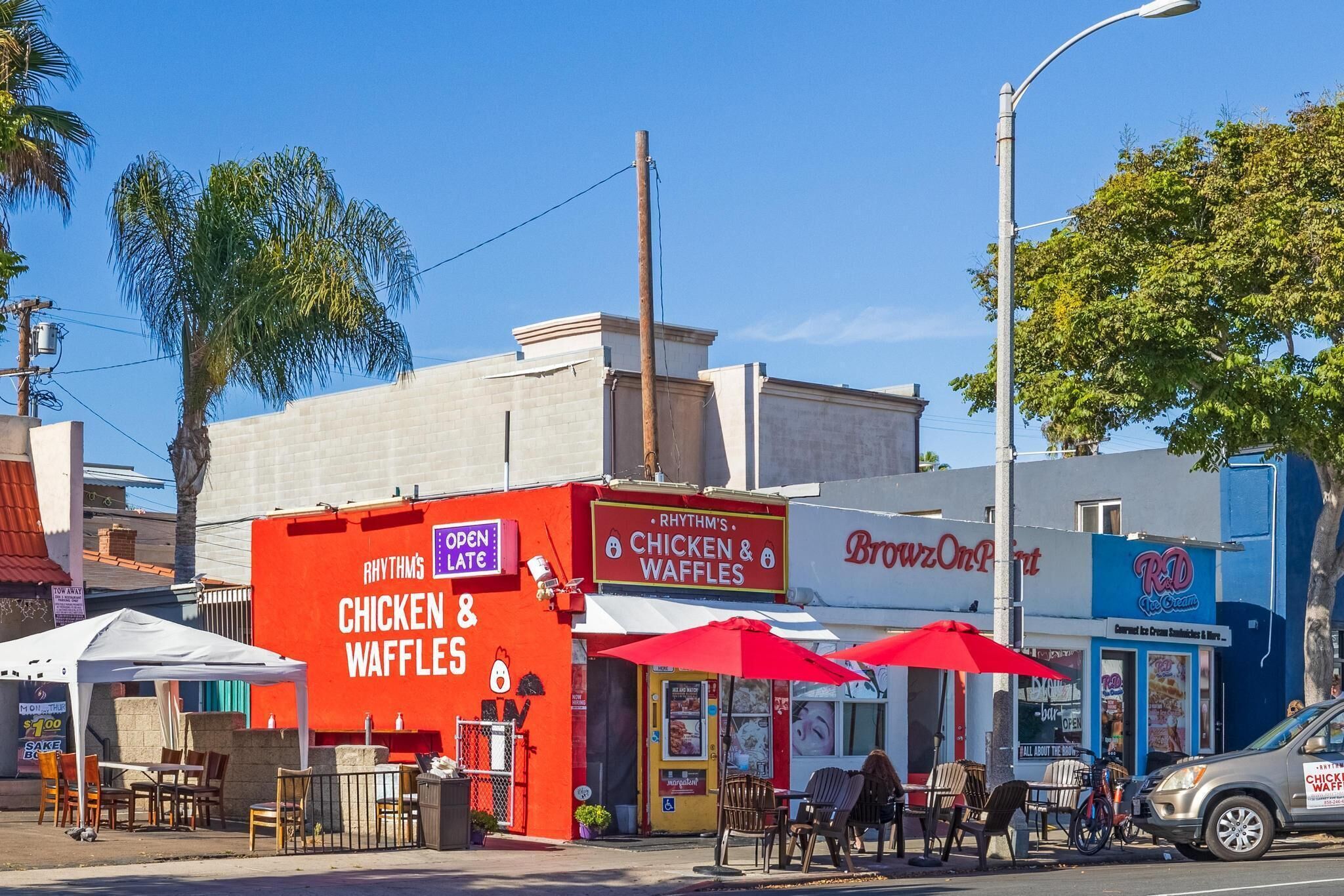 Straßenansicht mit einem Restaurant namens 'Rhythm's Chicken & Waffles' und einem weiteren namens 'Browz On'.
