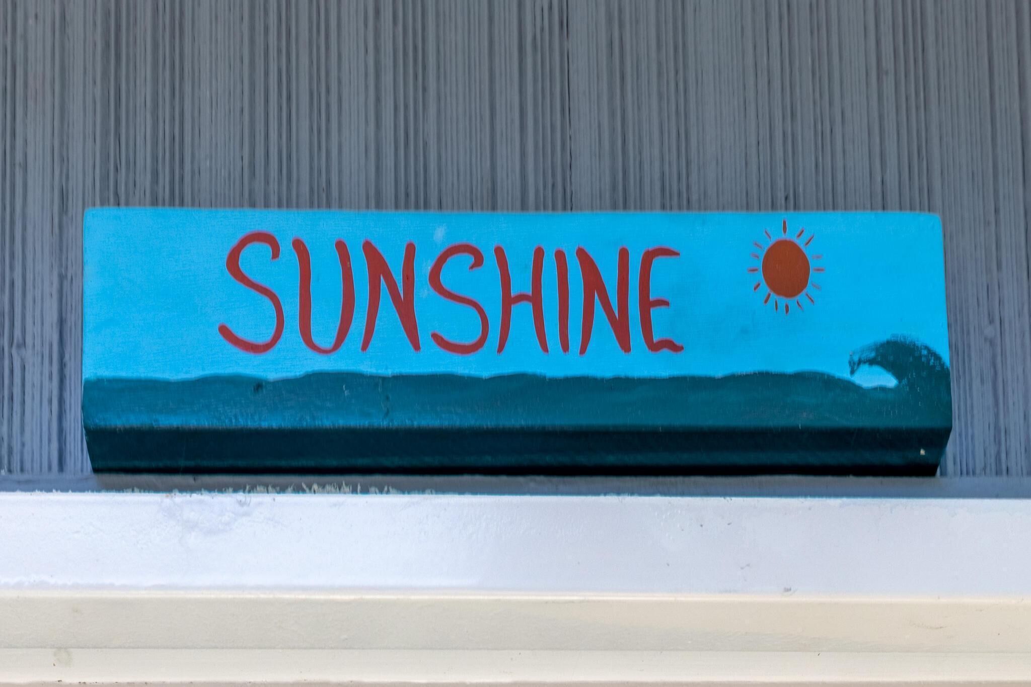 Kyltti, jossa on sana ”SUNSHINE” ja aurinkokuva.