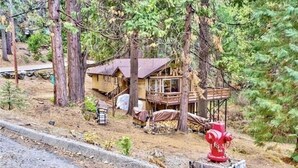 A cabin surrounded by trees, a red fire hydrant, and a wooden deck. - ManVee Lodge at Yosemite - Just 2 miles from the south gate entrance to Yosemite (fish camp)