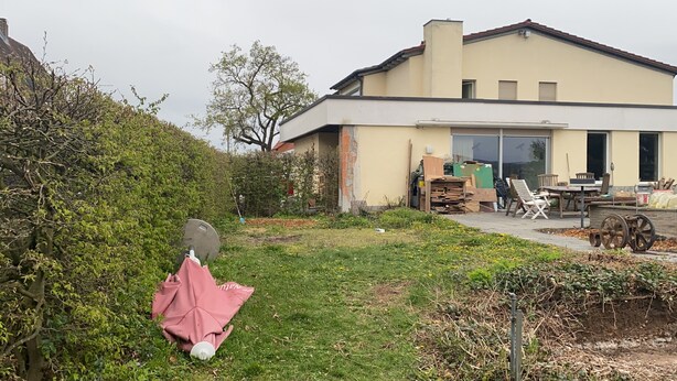 A modern house with a large garage, a patio with outdoor furniture, and a garden area. - The Finca - Your vacation in the Spanish Rhön (Hünfeld)