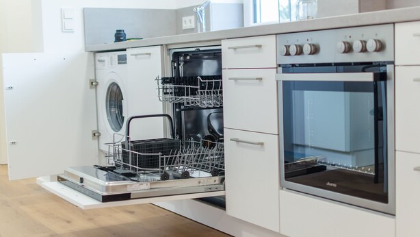 A modern kitchen with built-in appliances including a dishwasher and oven.