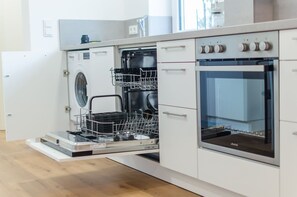 Una cocina moderna con electrodomésticos integrados, incluyendo lavavajillas y horno.