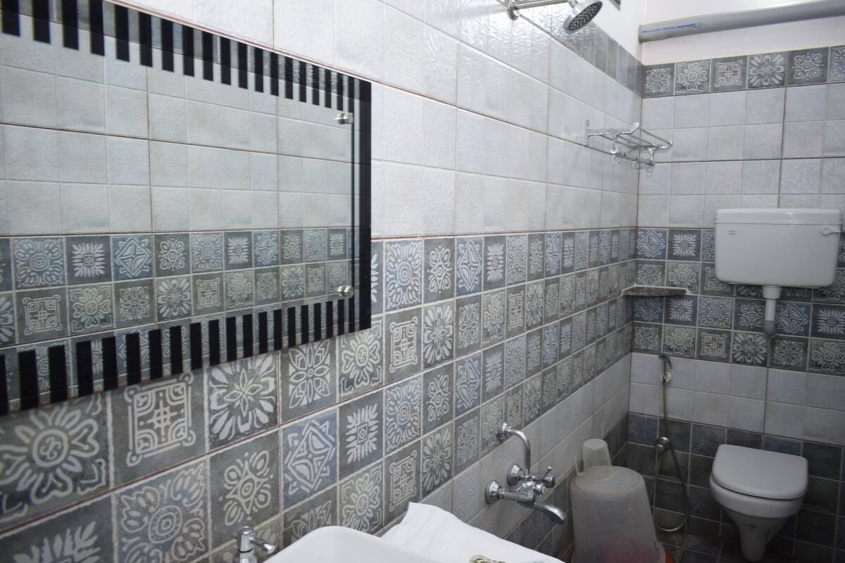 A bathroom with patterned tiles, a toilet, a sink, and a shower.