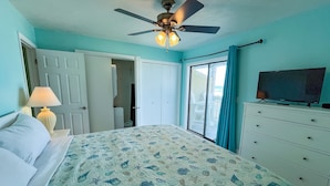 A bedroom with a bed, a ceiling fan, a television, and a view of the outdoors. - Fabulous 1BR Condo with amazing beach views sleeps 4. Park by door. Pool. (Panama City Beach)