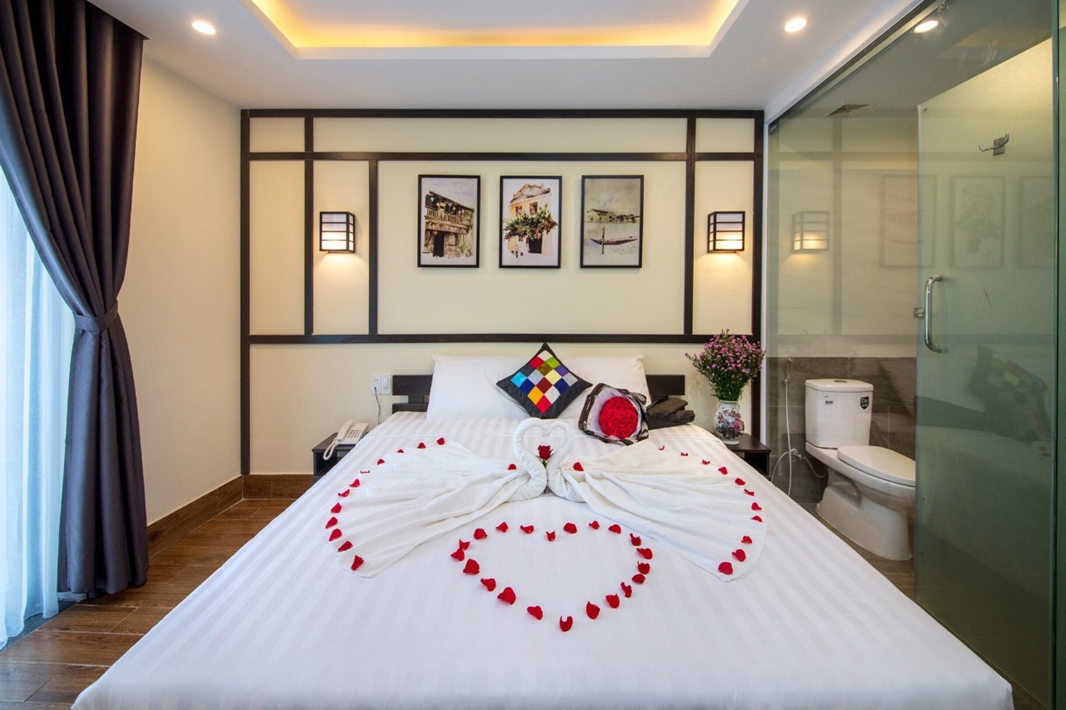 A hotel room with a neatly made bed, a shower, and a bathroom.
