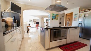 Una cocina moderna con una isla central, electrodomésticos de acero inoxidable y una alfombra roja.