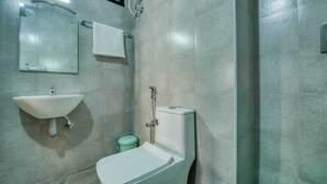 A bathroom with a white sink, a toilet, and a shower. - Corbelli Residency  (Puducherry)