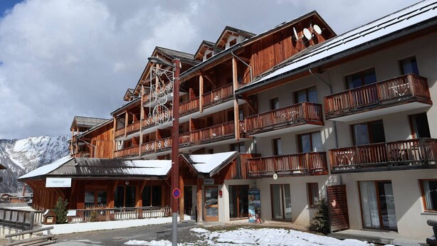 A multi-story wooden building with balconies, a ski lift, and a sign for 'neemys'. - Les Orres 1800: 3-room Apt, Pool, WiFi, Pets allowed (Les Orres)