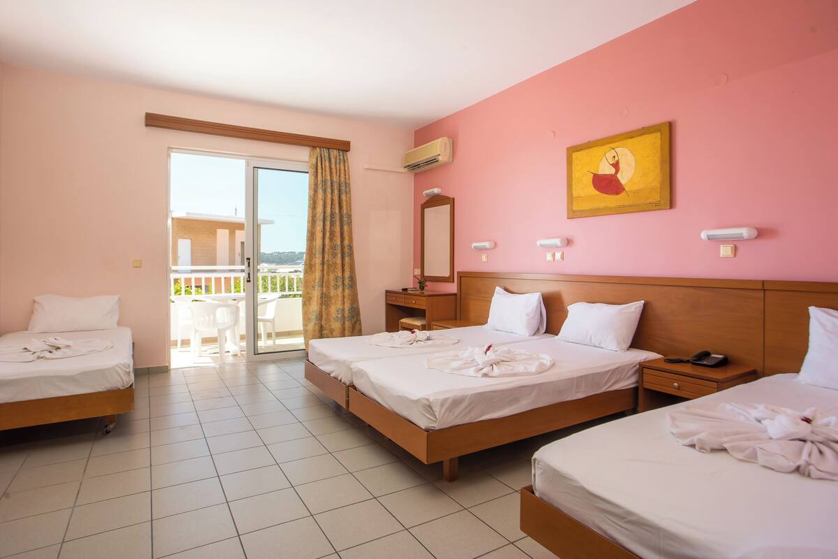 A hotel room with three beds, a balcony, a painting, and an air conditioning unit.