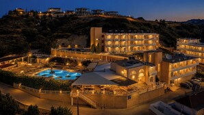 A hotel with a swimming pool, multiple balconies, and a view of the surrounding landscape. - Diagoras Hotel (Rhodes)