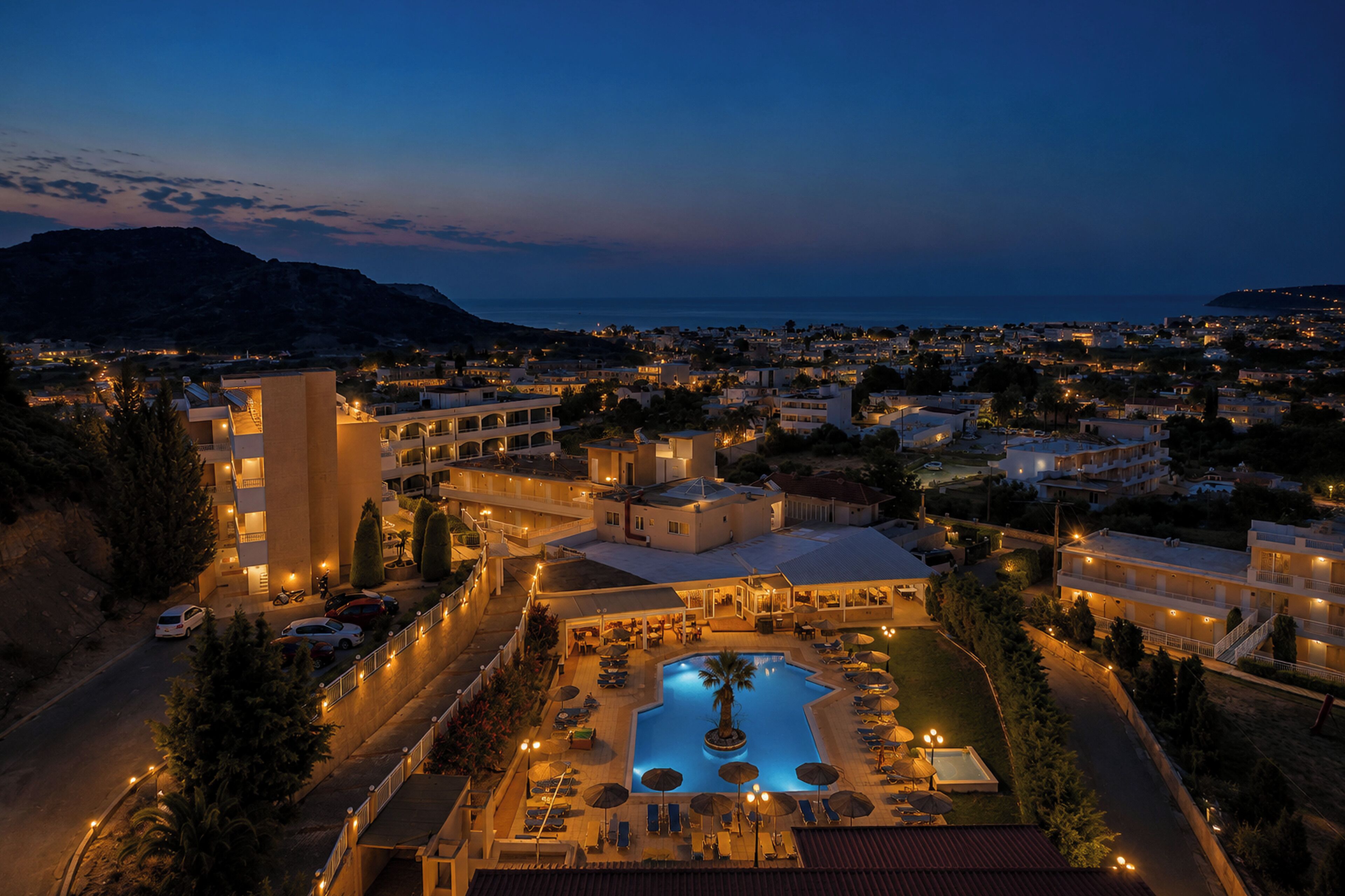 Un resort con piscina, varias construcciones y vista al mar.