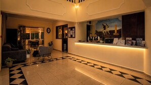 A hotel lobby with a reception desk, a staircase, a dining area, and a check-in counter. - Diagoras Hotel (Rhodes)