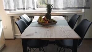 A dining table with a fruit bowl, black chairs, and a window with curtains. - Landliebeehrsen 2, modern, quiet location, parking lot.  (Bad Salzuflen)