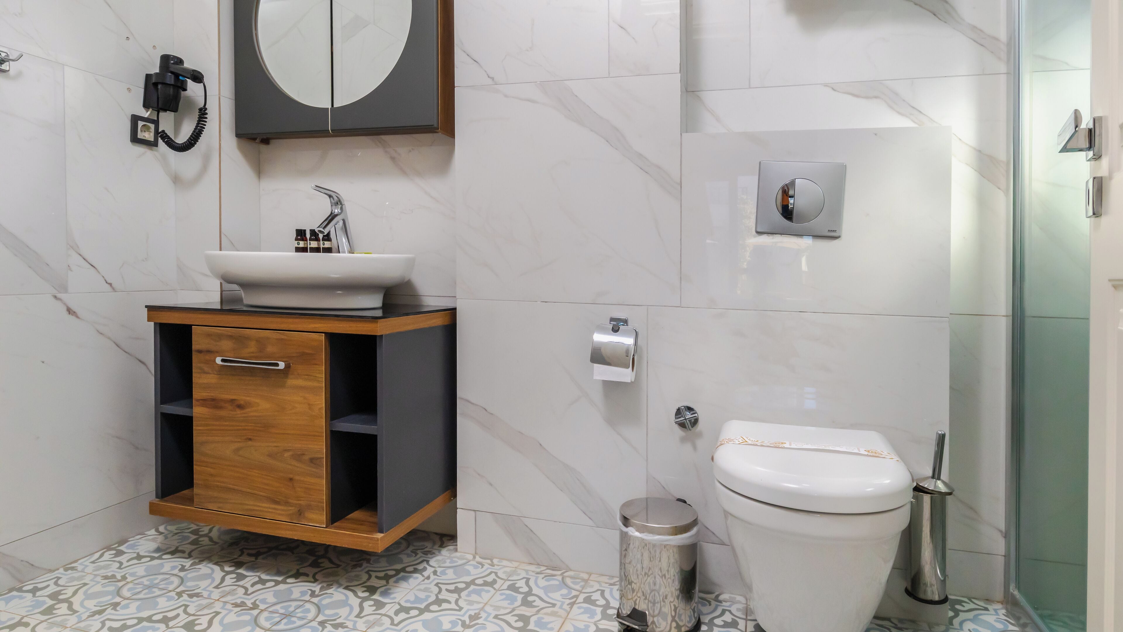Une salle de bain moderne avec un meuble-lavabo en bois, un lavabo blanc et des toilettes.