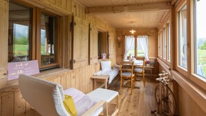 A wooden cabin interior with a bench, table, and a spinning wheel. - Rosenhaus 3 (Schwarzenberg)