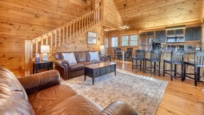 A spacious wooden cabin interior with a living area, a kitchen, and a dining area. - Hidden Hills, Cabin for Family Getaway with Mountain Views! - Hot Tub and Wifi (Blairsville)