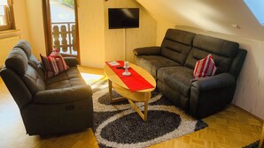 A cozy living room with a sofa set, a coffee table, and a TV mounted on the wall. - Quiet apartment on the outskirts of the city (Chemnitz)
