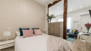 Une chambre moderne avec un grand lit, un bureau et un coin salon.