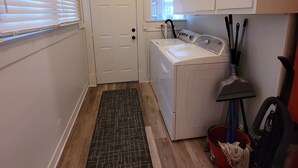 A laundry room with a washing machine, dryer, and cabinets.