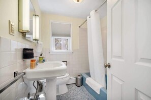 A bathroom with a white sink, toilet, and shower curtain.