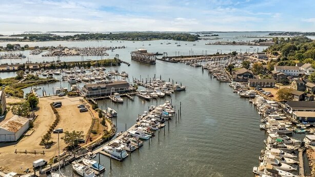 A marina with numerous boats docked, a large ship, and a small town with houses along the waterfront. - Downtown Mystic House w/ Yard, Pet-Friendly Getaway (Mystic)