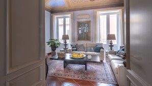 A well-lit living room with a sofa, coffee table, and decorative lamps. - Ortigia: A luxury apartment by the sea (Syracuse)