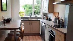 A modern kitchen with a central island, a dishwasher, and a stove. - Croak Cottage, backing on to Frogmore Creek, part of the Salcombe Estuary (Frogmore, Kingsbridge)