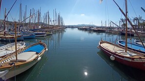 Una marina amb nombroses embarcacions amarrades, aigua tranquil·la i un cel serè.
