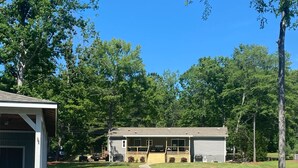 Un chalet au bord du lac, doté d’un quai, d’un espace salon couvert et d’une terrasse en gazon.