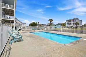 A swimming pool with a surrounding deck, a covered seating area, and a fenced perimeter. - Southern Seabreeze: Remodeled Home with Private Seasonal Pool and Great Ocean Vi (Oak Island)