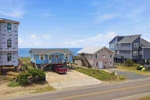 Ein Küstenwohngebiet mit Häusern, einer Straße und dem Meer im Hintergrund.