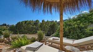 A sunlit outdoor lounge area with lounge chairs and a wooden pergola. - Wunderschönes Apartment mit Meerblick (Benissa)