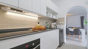 A modern kitchen with white cabinetry, a black countertop, and a digital oven display. - Wunderschönes Apartment mit Meerblick (Benissa)