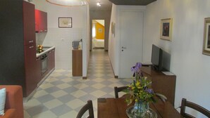 Un espace de vie compact comprenant une cuisine, un coin repas et une chambre.