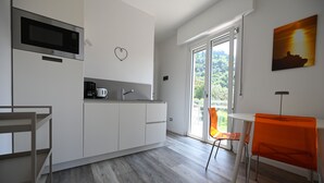 A modern kitchen with a microwave, coffee maker, and a heart-shaped decoration on the wall. - MODERN APARTMENT SECOND FLOOR AND PARKING SPACE APP SOLE (Malcesine)
