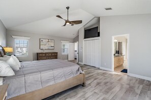 Un dormitorio con cama, cómoda, ventilador de techo y vestidor.