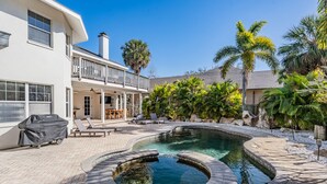 A house with a pool, outdoor furniture, and a covered patio area. - 5b Resort Style Pool Home! Tiki Bar, 1 mile to Popular Beach -Tropical Paradise! (Largo)
