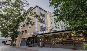 A multi-story building with a modern architectural design, featuring large windows and balconies. - Treebo Eden Park Hotel, 3 Km From Puducherry Airport (Puducherry)